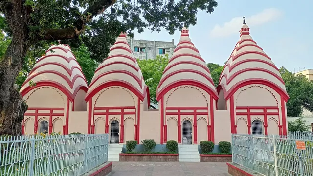 ঢাকেশ্বরী জাতীয় মন্দির চত্বরের সারিবদ্ধ চারটি চূড়াযুক্ত লাল-সাদা মন্দির ও সামনের পথ