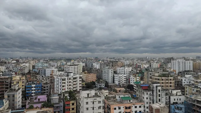 মেঘাচ্ছন্ন আকাশের নিচে ঢাকা শহরের ঘনবসতিপূর্ণ বহুতল ভবনের সারি।