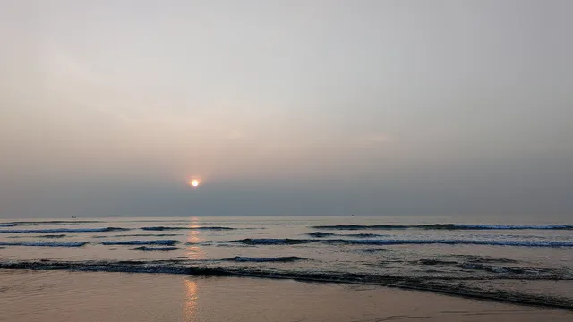 ইনানী সৈকতে ঢেউয়ের ওপর ভোরের সূর্য ও কুয়াশাচ্ছন্ন দিগন্ত।