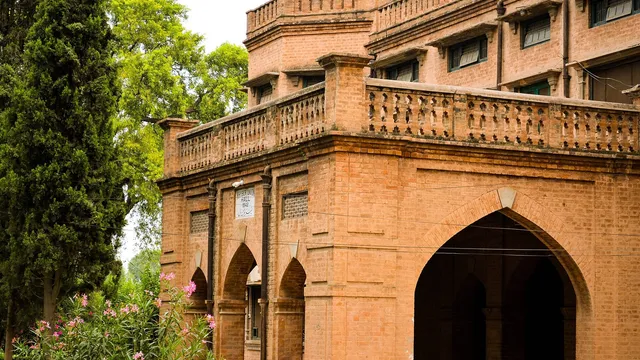 পেশোয়ারের ইসলামিয়া কলেজ ক্যাম্পাসের লাল ইটের একটি ঐতিহ্যবাহী ভবনের অংশ; পাশে গাছ ও ফুলের ঝোপ