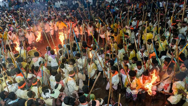 বাঁশের লম্বা লাঠি ও জ্বলন্ত মশাল হাতে অনেক মানুষের জমায়েত; ওপর থেকে তোলা ভিড়ের ছবি