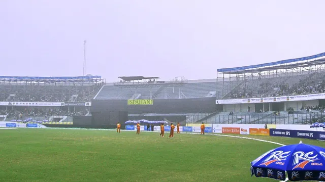 মিরপুরের শেরেবাংলা জাতীয় ক্রিকেট স্টেডিয়ামের মাঠ ও গ্যালারির একাংশ; সীমানার কাছে কয়েকজন মাঠকর্মী